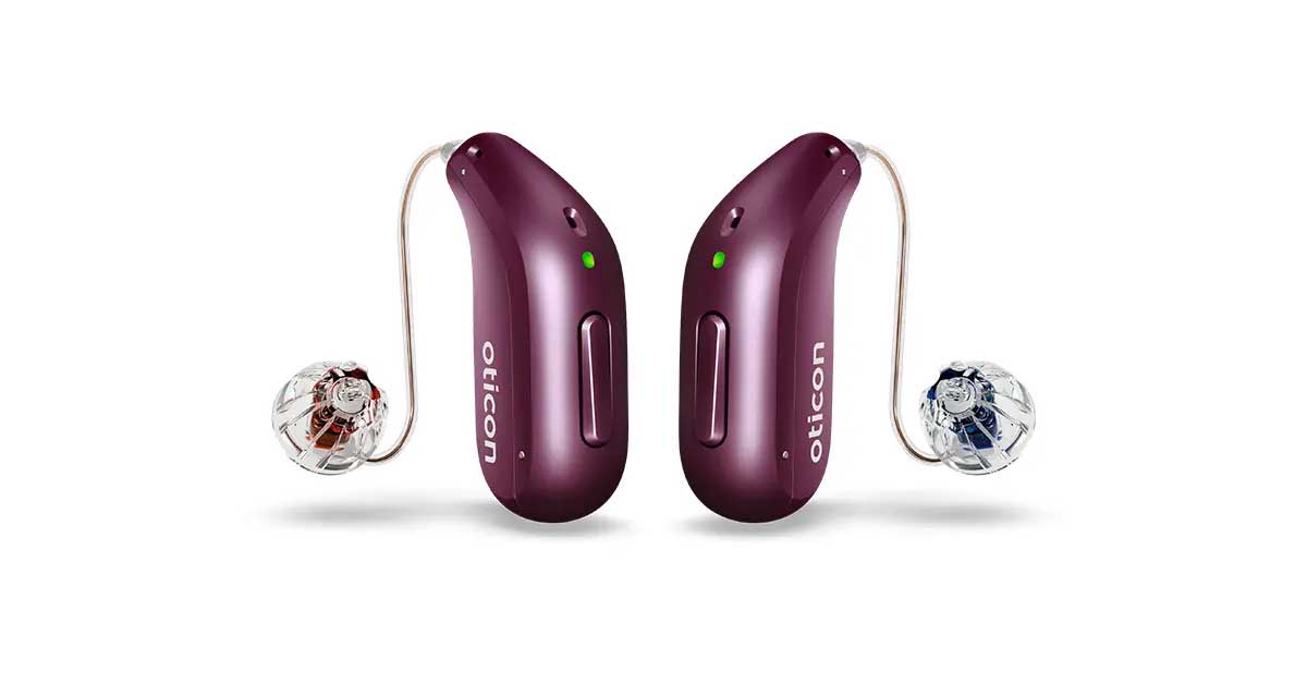 A pair of Oticon Reveal miniRITE R hearing aids in plum, with clear domes